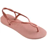 Ojotas Havaianas modelo Luna, color rosado metalizado, con tiras finas que se cruzan y forman un lazo en el empeine, y tiras traseras ajustables.