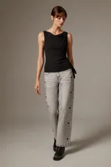 Blusa de poliéster negra, sin mangas, con cuello asimétrico, detalles bordados y sutiles lentejuelas.
