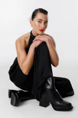 Bota corta de cuero negro con cierre lateral, plataforma y taco geométrico.