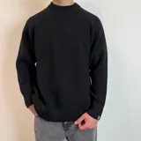 Sweater verde oliva de tejido grueso con cuello alto y mangas raglán. Corte holgado.