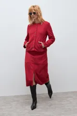 Chaqueta de textura simil gamuza en color rojo, con cuello redondo, cierre frontal mediante botones metálicos y bolsillos laterales.