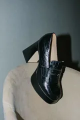 Mocasines color beige con estampado de piel de cocodrilo, plataforma y tacón cuadrado.