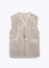 Chaleco de piel sintética color crudo, con cuello en V y bolsillos laterales.