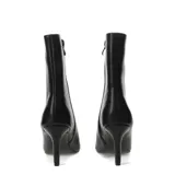 Botín de caña media color negro, con punta fina y taco alto y delgado. El material parece ser cuero sintético liso.