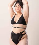 Bombacha de tiro alto confeccionada en una combinación de lycra y microtul, con diseño de doble tira cruzada en la cintura y breteles regulables con enganches metálicos.