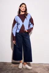 Sweater de tejido de punto con diseño de rombos (argyle) en tonos azul claro y marrón oscuro. Presenta cuello redondo y puños y cintura acanalados.