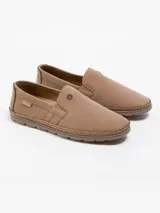 Calzado tipo mocasín de estilo urbano en color tostado, confeccionado en eco-cuero con costuras perimetrales reforzadas a la vista, elásticos laterales para un calce rápido y suela de PVC flexible.