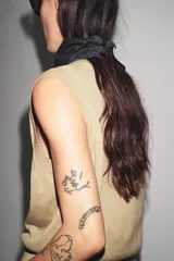 Chaleco de tejido de punto color camel, con escote en V y cierre frontal de botones oscuros.