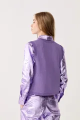 Chaleco de punto color lila con lurex, sin mangas y cuello redondo.