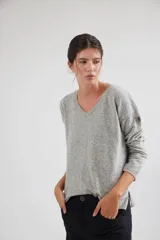 Buzo de escote en V y manga larga, confeccionado en lana lambswool. Presenta un diseño básico con detalle de raya en contratono en una de las mangas, puños y ruedo en color contrastante, y pin metálico de la marca aplicado en la manga.