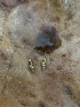 Par de aros colgantes dorados con forma de concha marina.