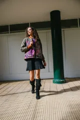 Chaqueta bomber con estampado abstracto en tonos verdes, rosas y naranjas. Tiene cuello, puños y ruedo acanalados en color naranja.