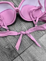 Corpiño de bikini con breteles regulables, relleno desmontable y push-up. Se ata en la espalda.