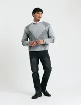 Sweater de punto con diseño de rombos en gris y azul marino, escote redondo a la base, manga larga y terminaciones en punto acanalado en cuello, puños y ruedo.