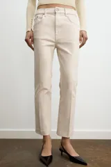 Jeans de mezclilla azul claro, tiro medio, corte recto y ligeramente acampanado en el bajo. Presenta cinco bolsillos y cierre frontal con cremallera y botón metálico.