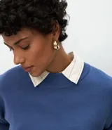 Buzo suéter de tricot con cuello redondo y puños ajustados, de diseño clásico y versátil.