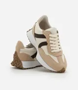 Championes estilo jogging con diseño de paneles en tonos gris, blanco y negro. Presentan cierre por cordones, suela de goma con relieve que se extiende hacia el talón y acabado en poliuretano.