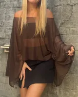 Top tipo poncho de tela traslúcida color marrón, con diseño de hombros descubiertos y mangas amplias tipo murciélago.