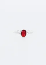 Anillo de plata 925 con zirconia roja ovalada de 7mm y zirconias blancas pequeñas a los lados.