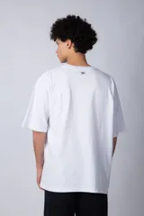 Remera de corte oversize, color blanco, con cuello redondo y mangas cortas amplias.