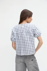 Camisa a cuadros de manga corta abullonada y cuello redondo, con cierre frontal de botones.
