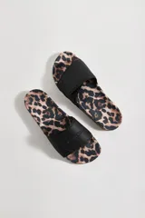 Sandalias tipo ojota con base estampada animal print y tira ancha negra ajustable con velcro, con logo de la marca grabado.