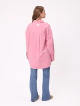 Camisa de manga larga con efecto lavado, corte oversize y cierre frontal con botones. Presenta cuello clásico y logo bordado en el pecho.