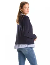 Buzo de punto fino color beige con diseño de camisa incorporada. Presenta escote en V con cierre frontal de botones, mangas largas con puños acanalados y cuello y ruedo con estampado de rayas verticales que simulan una camisa debajo.