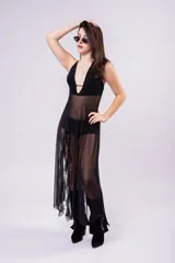 Vestido largo de tul color marrón con diseño de top halter y falda con volados laterales. Presenta una estructura de malla semitransparente que aporta movimiento y elegancia.