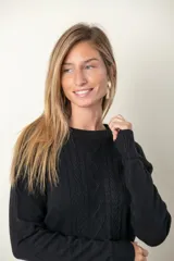 Sweater rojo de punto con cuello redondo, mangas largas, trenzado central y bolsillos delanteros.