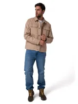 Chaqueta de canvas color beige con forro interior de franela. Presenta cierre frontal con botones metálicos, bolsillos en el pecho con solapa y bolsillos laterales. Incluye etiqueta de marca en el bolsillo inferior.