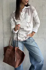 Sweater de punto con diseño floral en tonos beige y blanco, cuello tipo polo y mangas largas.