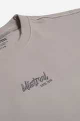 Remera de manga corta con textura marcada, cuello redondo y logo bordado frontal de la marca Mistral.