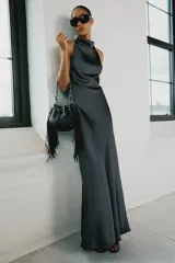 Vestido largo satinado color gris oscuro, con cuello halter, hombros descubiertos y cierre en la espalda con cremallera oculta.
