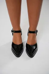 Sandalias negras de charol con punta cuadrada, tira sobre el empeine con hebilla metálica y tacón ancho.