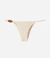 Bombacha de bikini colaless color beige, confeccionada en microfibra acanalada con laterales finos y detalle de aplique circular carey en el lateral derecho.