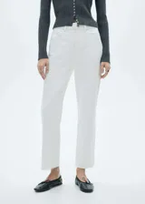 Jeans blancos de corte recto y tiro medio, confeccionados en tejido denim de algodón. Presenta diseño crop con bajo deshilachado, estilo clásico de cinco bolsillos, trabillas para cinturón y cierre frontal con cremallera y botón metálico.