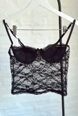 Top de encaje negro con breteles finos y copas con aro.