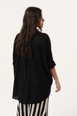 Camisa negra de tejido calado, con escote en V, abotonada y manga 3/4.