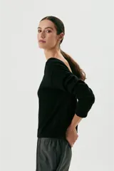 Sweater negro de lana con escote en V profundo que puede usarse tanto de frente como de espalda.