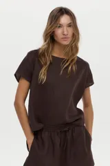 Blusa de lino color blanco, con cuello bote y mangas cortas de corte holgado.