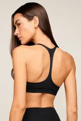 Top deportivo blanco de poliamida con diseño de espalda nadador, breteles medios y banda elástica inferior para mayor soporte. Cuenta con forro interno y entrada para copas removibles.