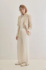 Blazer sastrero de lino color beige, de silueta relajada y líneas clásicas. Incorpora solapas tradicionales, cierre frontal de un botón y bolsillos de vivo.