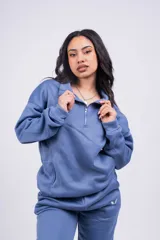 Buzo negro con cierre de media cremallera, cuello alto y logo bordado en el pecho.