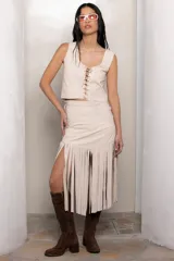 Falda midi de cuero color beige, con diseño de flecos largos en el ruedo y detalles de trenzado en los laterales.
