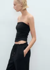 Pantalón de corte recto y tiro medio, confeccionado en mezcla de lino y viscosa. Presenta cintura elástica con cordón ajustable, dos bolsillos laterales y diseño largo.