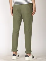 Pantalón de lino color verde oliva, de corte recto y con ruedo arremangado.