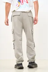Pantalón cargo color gris claro, de corte amplio, con múltiples bolsillos con solapa y ajuste con cordón en la cintura.