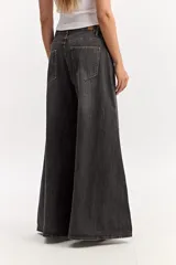 Pantalón jean súper oxford de tiro medio, color gris oscuro con efecto gastado, ajustado en la parte superior y con una apertura extra amplia hacia el ruedo.