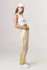 Pantalón de jean corte regular con acabado metalizado plateado, diseño de cinco bolsillos y cierre frontal con botón y cremallera.